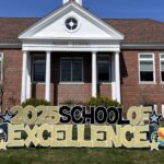 Photo of school with 2025 School of Excellence sign in front yard